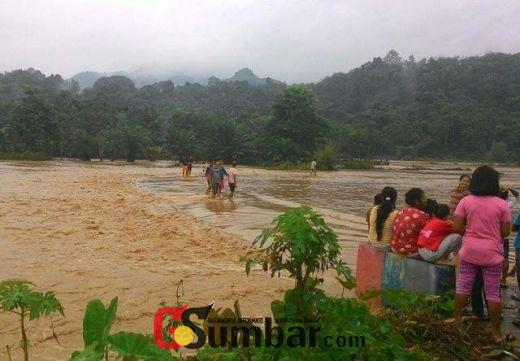 Warga menyaksikan terjangan banjir di Pangkalan.