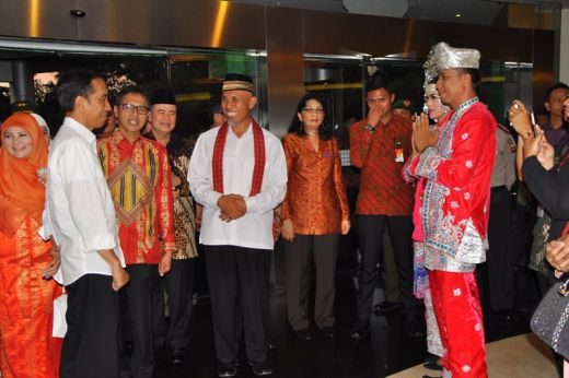Presiden Jokowi saksikan pagar ayu berpakaian adat Minangkabau.