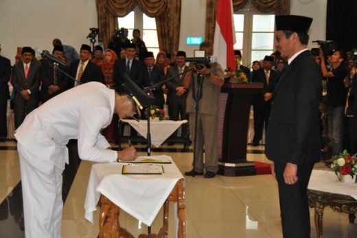 Bupati Hendrajoni menandatangani surat berita acara serah terima disaksikan Gubernur Irwan Prayitno.
